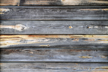 Texture of the wall made of wooden panels with multiple knots and cracks as a rural natural...