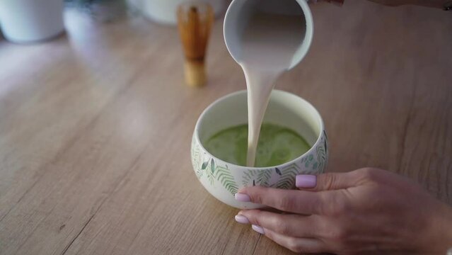 Women brews matcha green latte tea 