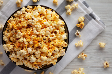 Homemade Pop Corn with Cheese in a Bowl on a white wooden background, top view. Flat lay, overhead, from above.
