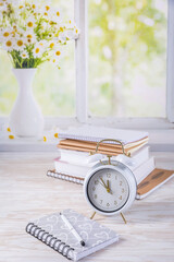 Alarm clock and books - time management and procrastination concept