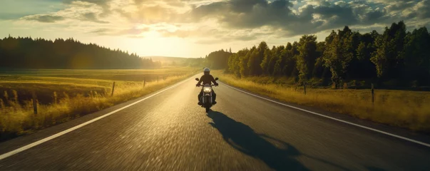 Selbstklebende Fototapeten Driver riding motocycle on empty road in sunset light.  Panorama photo. © amazingfotommm