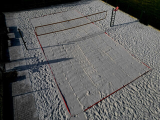 white sand beach volleyball court. white soft dunes fenced with nets. The lines of the playing...