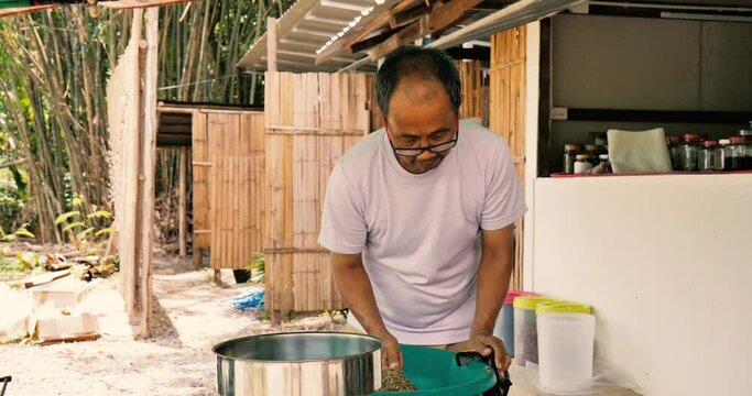 Asian man mixing seeds such as pumpkin seeds, gunks, cur, cumin. Slowmo, 4k