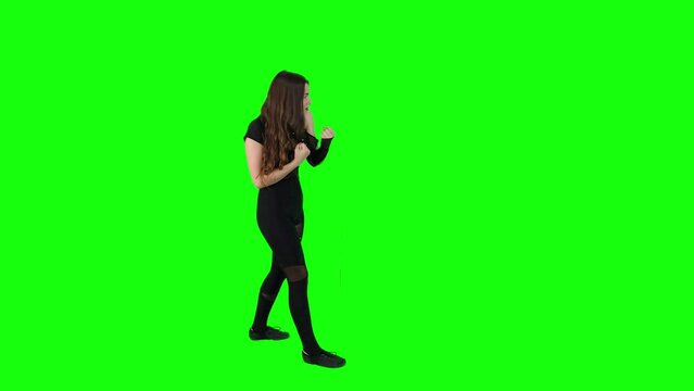 Attractive young female acting a fight scene in front of a green screen