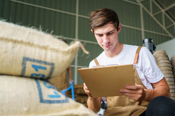 Warehouse workers examining and checking an agricultural stock inventory in the storage house or barn. 