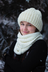 Woman is a young portrait. In a white hat on the street. Winter, Conifers