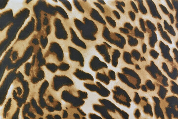 leopard pattern textile, brown and black striped repeated on beige fabric