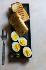 Breakfast food ingredients bread and egg on a black tray. Selective focus.