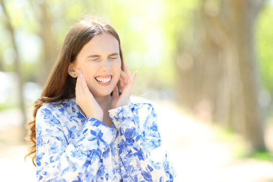 Woman suffering mandibular ache in a park