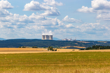 Fototapeta na wymiar Summer fields and Temelin nuclear power plant on the horizon