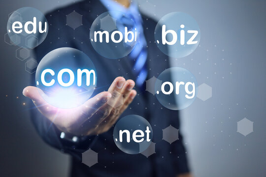 Businessman hand holding and choosen bubble sub domain name to dot com or .com to registeration the commercial website. Domain selection concept.