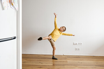 Happy boy doing mischief and having fun in front of white wall