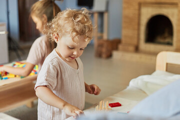 Colorful sorting shapes. Preschool learning games. Colorful sorting shapes. Creative art exploration. Little girls playing with educational toys at home interior.