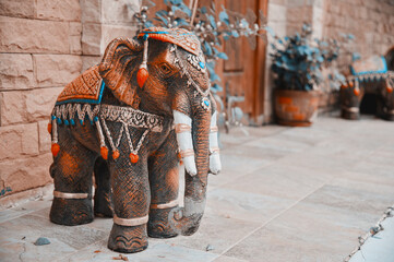 A figurine of a garden elephant stands at the entrance at the gate