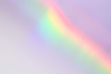 Abstract holographic retro rainbow light refraction texture overlay. Organic drop diagonal holographic flare on a white wall background. Natural shadows and light effect