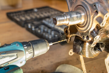 Metal shavings are produced during threading. Car mechanic repairs the hub bearing. Tools box in...