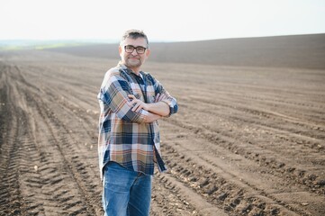 Portrait of senior farmer with glasses in field