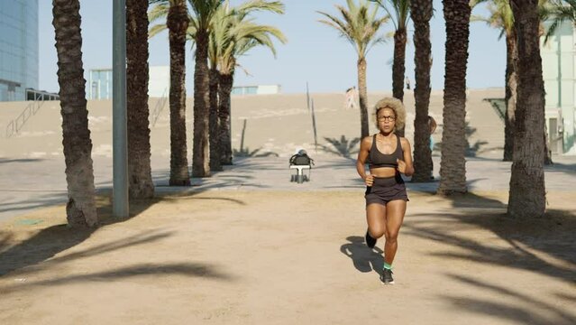 African woman starting to run in a park in summer