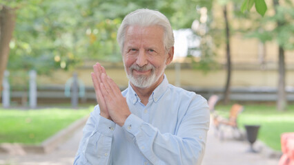 Outdoor Portrait of Excited Senior Old Man Clapping for Team