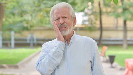 Outdoor Portrait of Senior Old Man with Toothache