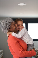 Happy african mother and toddler son hugging at home.