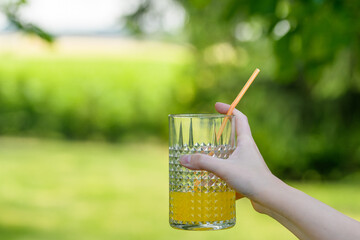Szklanka z sokiem pomarańczowym trzymana w ręce 