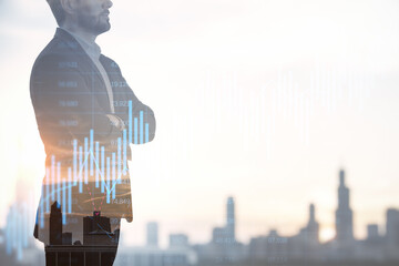 Successful young businessman silhouette with folded arms using forex chart hologram on blurry city...