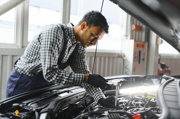 Indian happy auto mechanic in blue suit.
