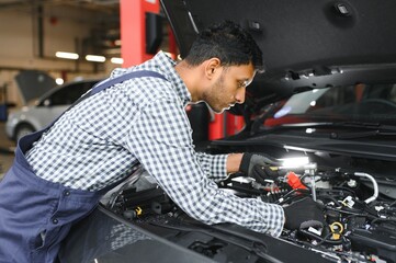service, repair and profession concept - indian mechanic at car service