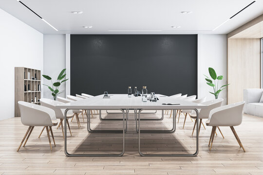 Side view of modern empty conference room with white office desk and chairs, black wall, wooden floor, and houseplant. 3D Rendering