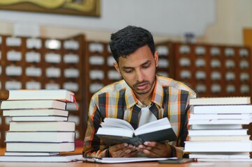 Happy smart indian or arabian guy, mixed race male, university student, in the library