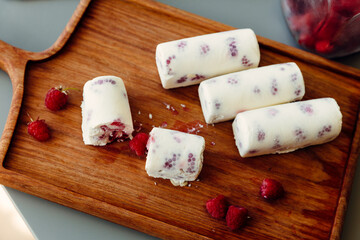 Frozen dessert with raspberries, serverovan berries on a wooden board. Homemade food, dessert, cake. Healthy food, health care.