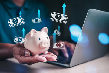 Saving investment plan, save for life concepts. Asian man using laptop planning save money in to piggybank. Saving for retirement, Education cost plan.