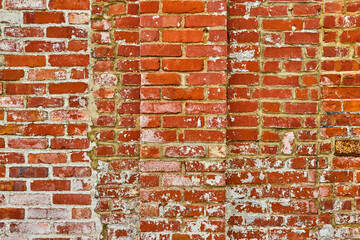 Background asset decaying and layered red brick wall with flecks of white paint