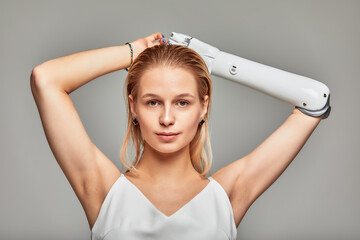 Close-up studio portrait of beautiful young blonde girl with disability wearing sensory bionic...