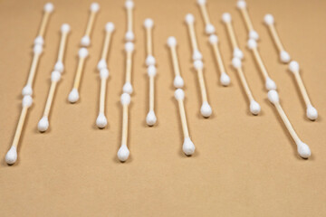 A lot of wooden cotton buds lie on a beige kraft paper background.  Zero waste concept