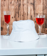 Embrace the allure of wine-inspired fashion with this captivating mockup image showcasing a white blank hat, beautifully arranged in a themed setup
