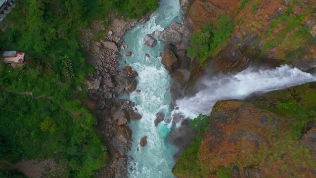 Aerial top down view beautiful Waterfall in Chyamche village in river gorge surrounded by green himalayan nature - Annapurna Circuit trek. Way to Manang.Himalayas mountains flora.