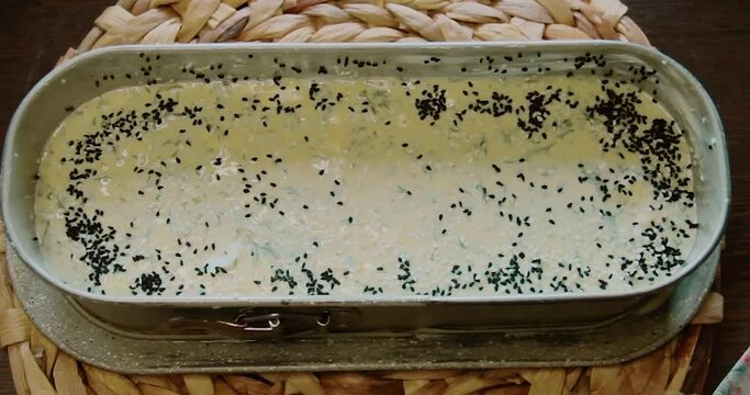 Cake mortar is put into the cake mold, black cumin, olives and peppers are added on it
