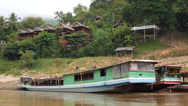  Slow Wooden Tourist Boats on Mekong River at Pak Beng Village, High Quality 4K Slowmotion Tourism and Travel in South East Asia Concept Footage. Laos.