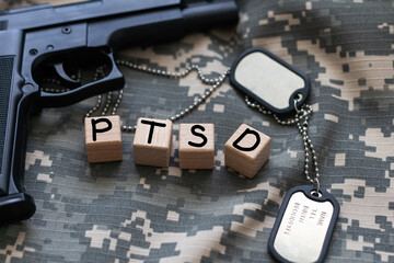 the word PTSD laid with silver metal letters on flat rusted steel sheet background in slanted...
