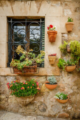 Fototapeta na wymiar Charming and cozy wall with flower pots on a traditional house in Valldemossa, Mallorca