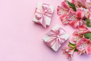 Beautiful Alstroemeria flowers and gift boxes on pink background