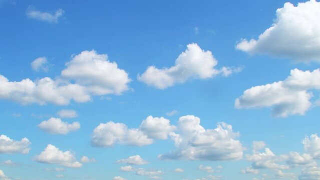 Blue sky with slowly moving white clouds. Calm, relaxing background.