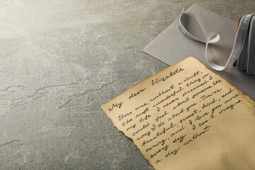 Vintage letter with text, envelope and ribbon on gray background, space for text