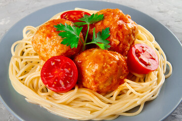 Delicious meatballs made from turkey in spicy tomato sauce served with pasta, close-up