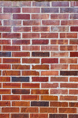 Vertical background asset red brick wall with varying hues and white mortar