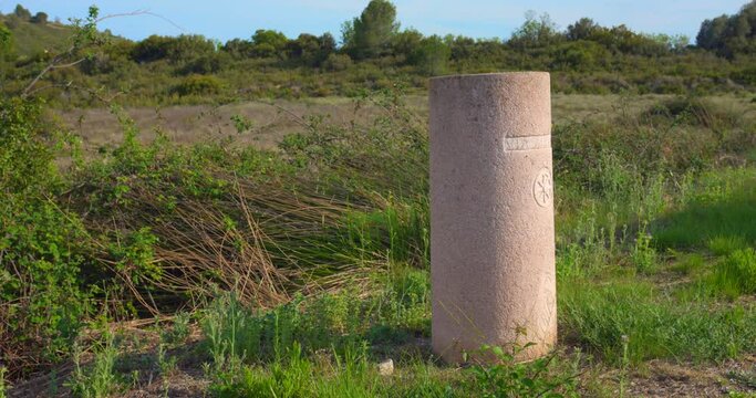 Via Augusta Concrete Marker On The Grassy Field In Castellon Province, Spain. - wide
