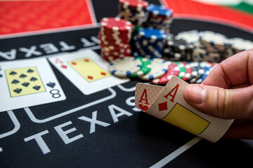 player is holding two ace cards - win combination at poker