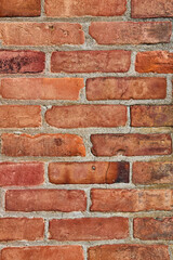 Vertical shot of cracked and dirty or grimy red brick wall background asset
